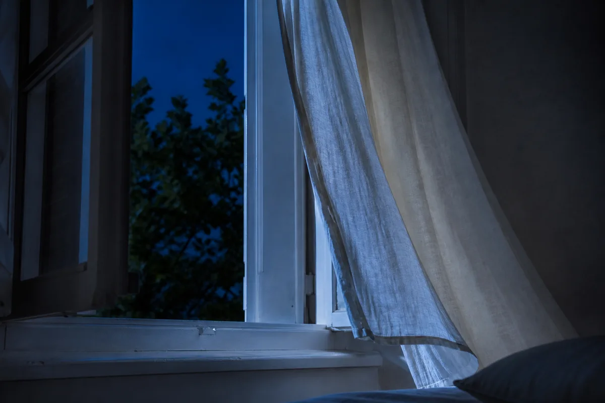 Fenêtre entrouverte sur une nuit d&rsquo;été, rideau clair soulevé par l&rsquo;air